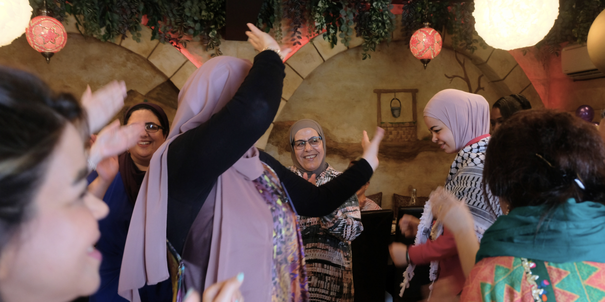 Women from across the world dance together at a JRS Australia celebration for International Women's Day 2024.