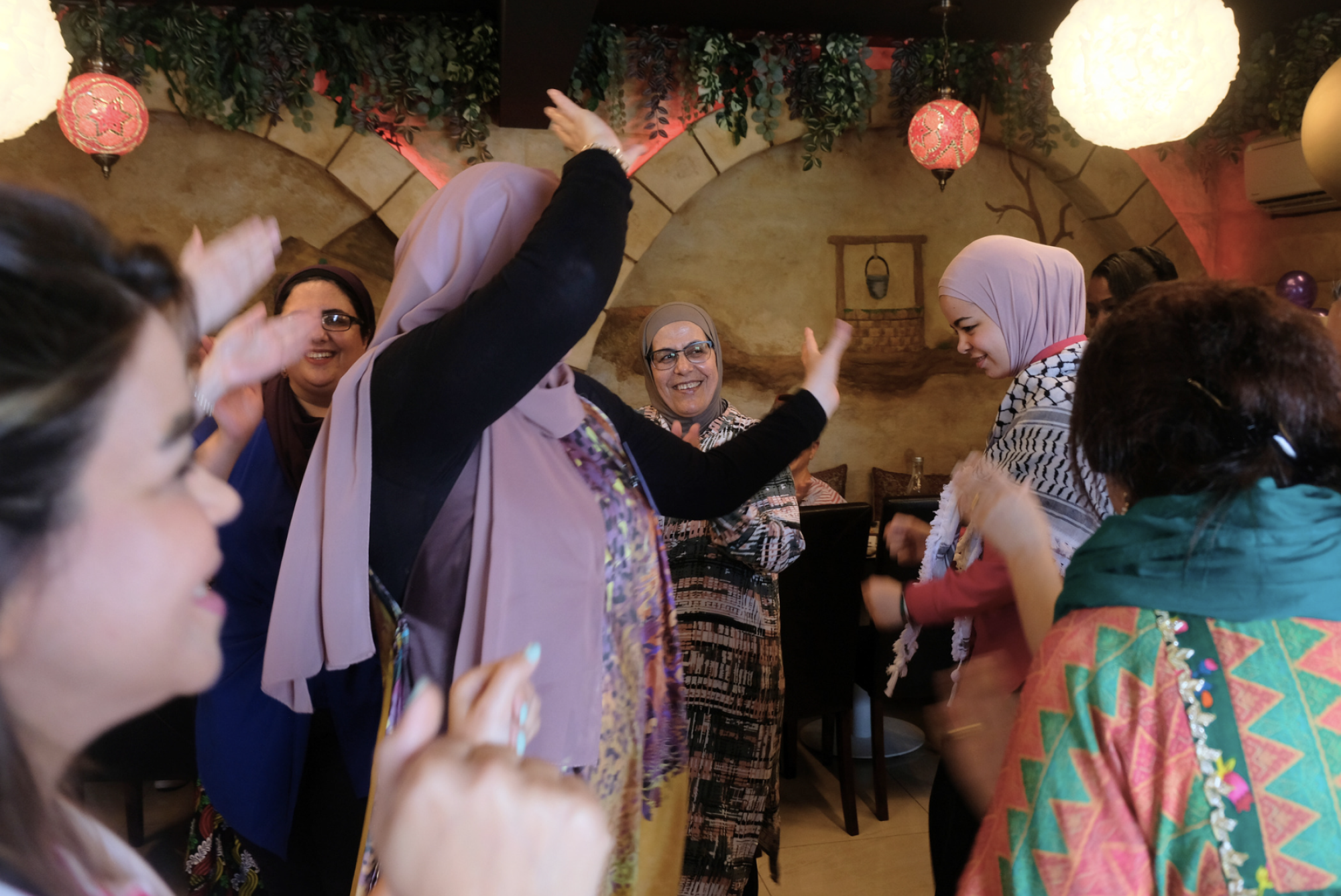 Women from across the world dance together at a JRS Australia celebration for International Women's Day 2024.