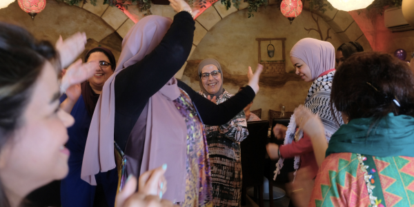 Women from across the world dance together at a JRS Australia celebration for International Women's Day 2024.