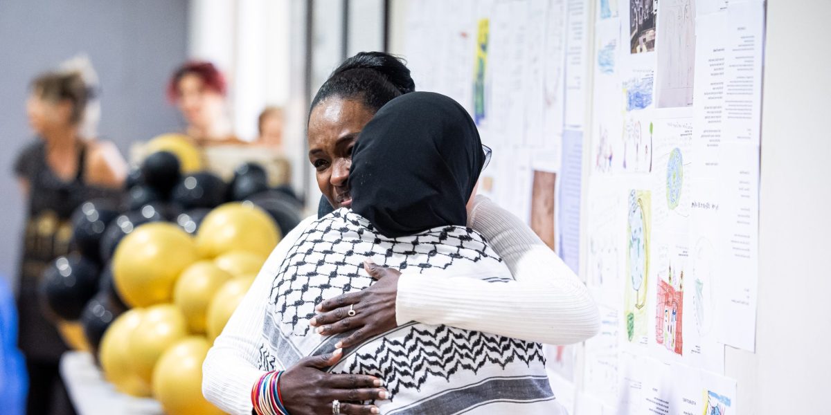 Sara Muzamil, JRS Australia Finding Safety Project Coordinator, shares a hug with a guest at our 